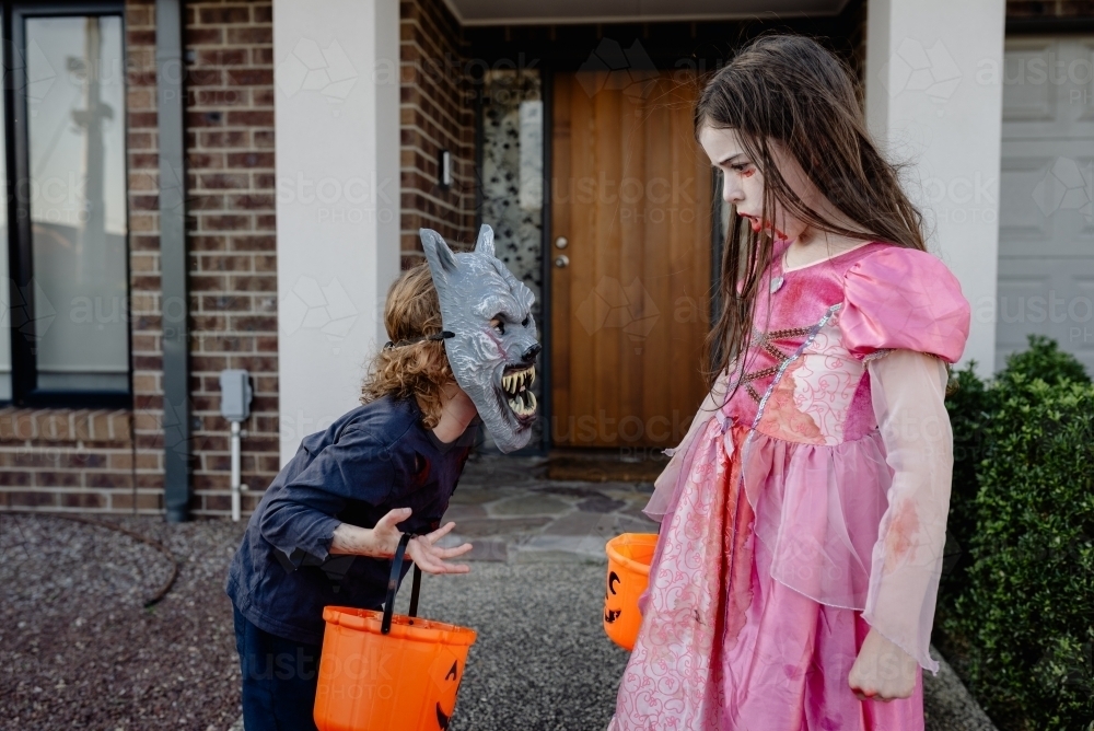 Two children dressed up for Halloween ready to trick or treat; a boy werewolf & vampire princess - Australian Stock Image