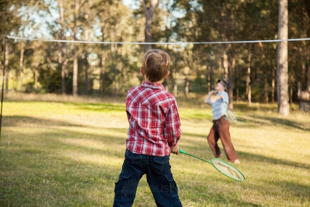 Two children playing badminton in the backyard - Australian Stock Image