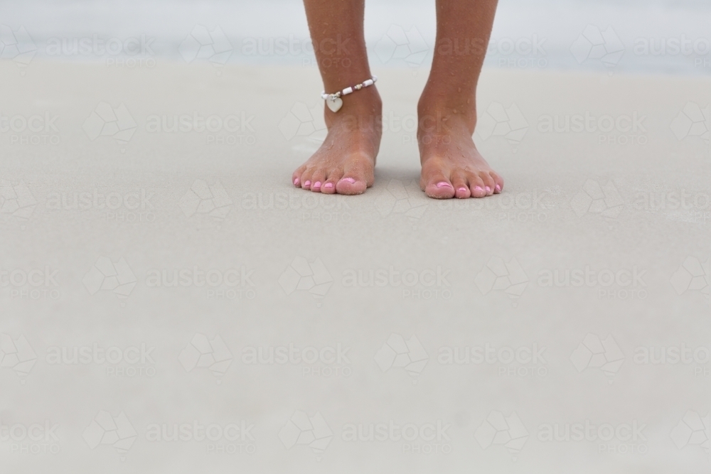 Two feet standing on sandy beach - Australian Stock Image