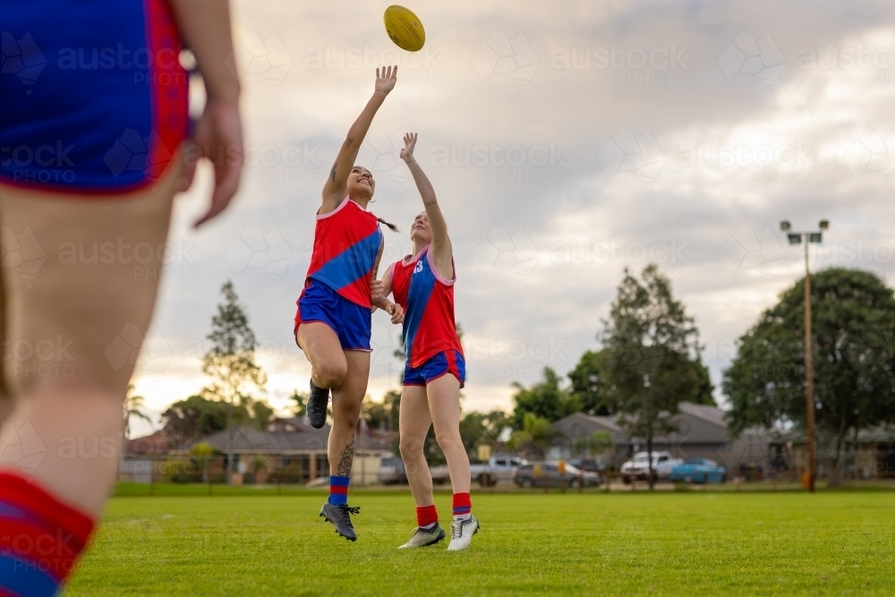 two female football players jumping for the ball at training - Australian Stock Image