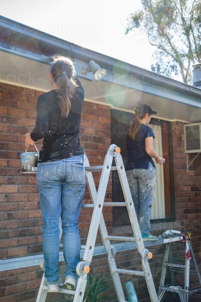 Two female painters Painting home exterior - Australian Stock Image