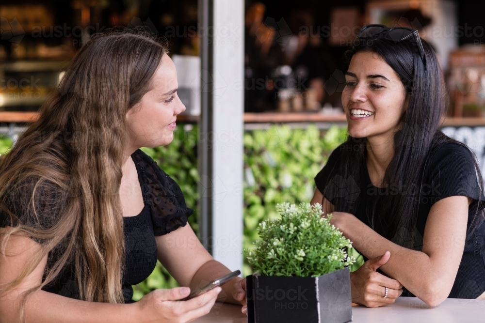 two friends chatting in a cafe - Australian Stock Image