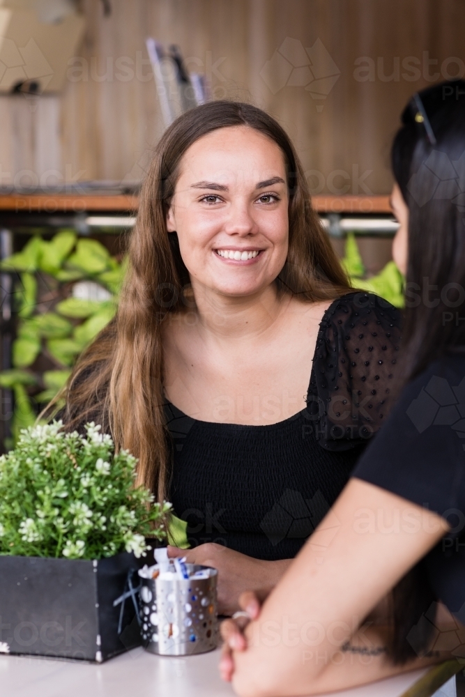 two friends chatting in a cafe - Australian Stock Image