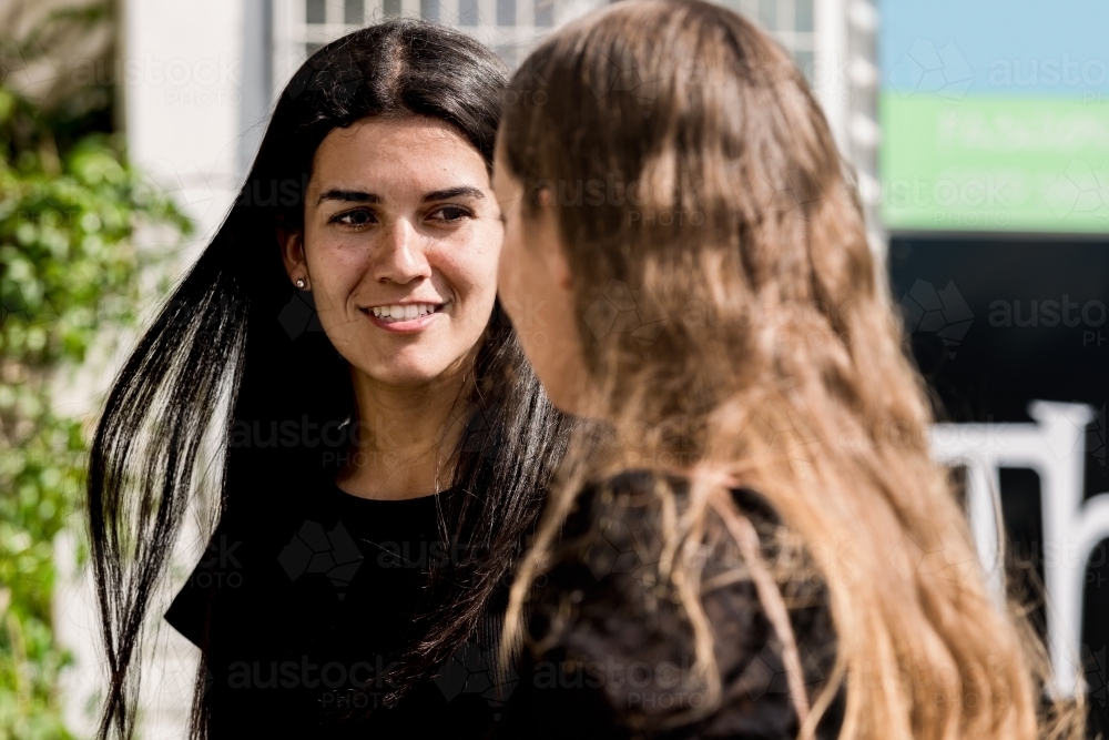 two friends chatting outdoors - Australian Stock Image