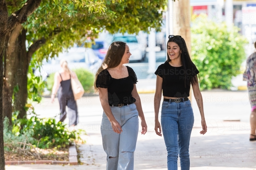 two friends walking in the street - Australian Stock Image