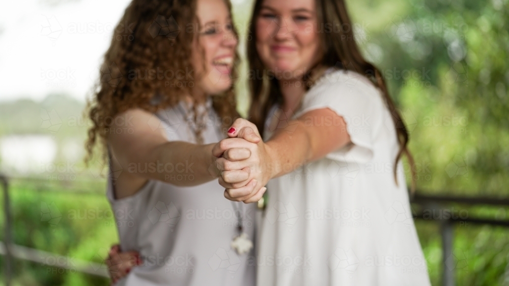 Two girls holding hands blurred focus - Australian Stock Image