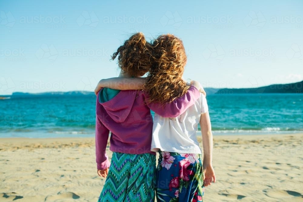 Image Of Two Girls Hugging At The Beach - Austockphoto