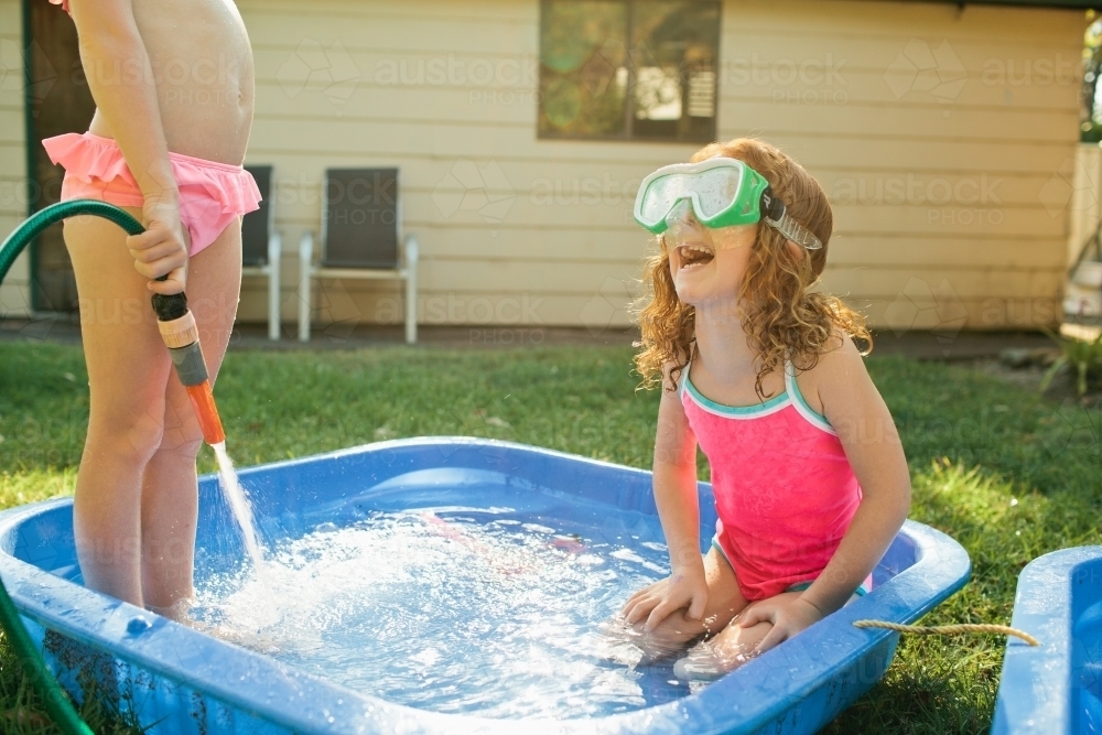 Two girls playing in a paddling pool - Australian Stock Image