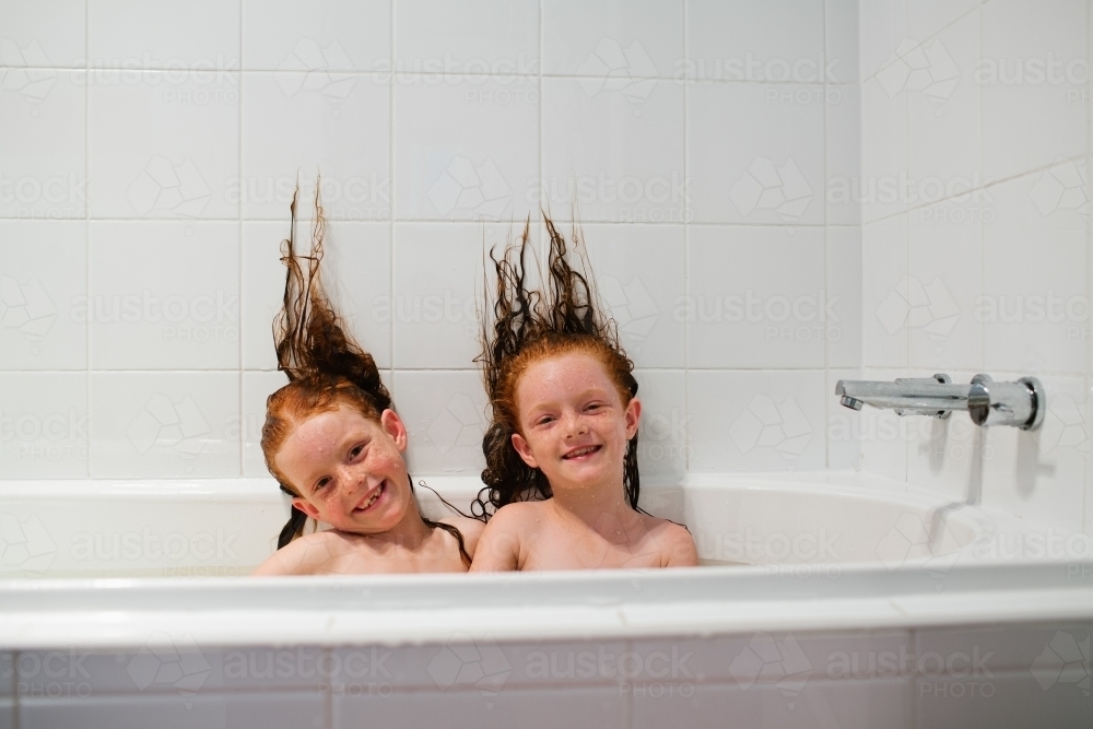 Two girls sitting in a bath - Australian Stock Image