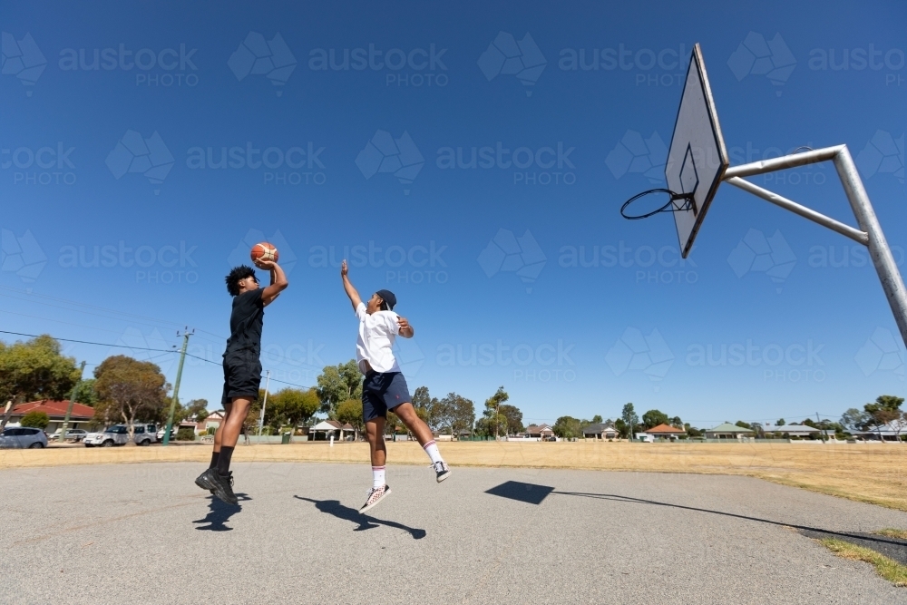 Two guys playing one-on-one basketball - Australian Stock Image