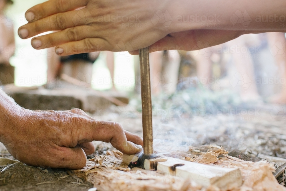 Two hands engaged in flint knapping to create fire. - Australian Stock Image