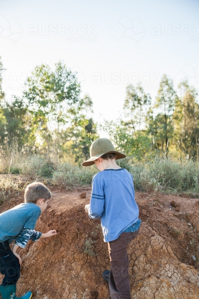 Two happy boys playing in the dirt outside - Australian Stock Image