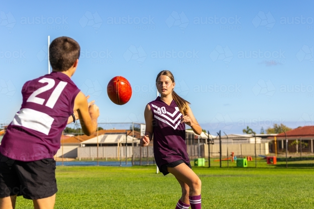 two kids handballing at football training - Australian Stock Image