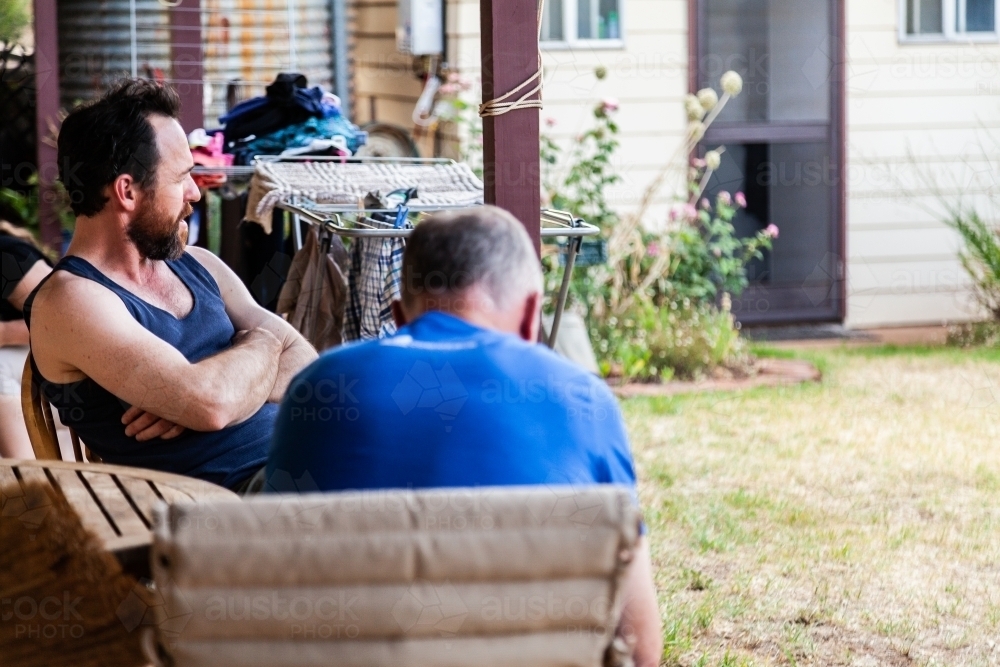 Two men chatting together on verandah - Australian Stock Image