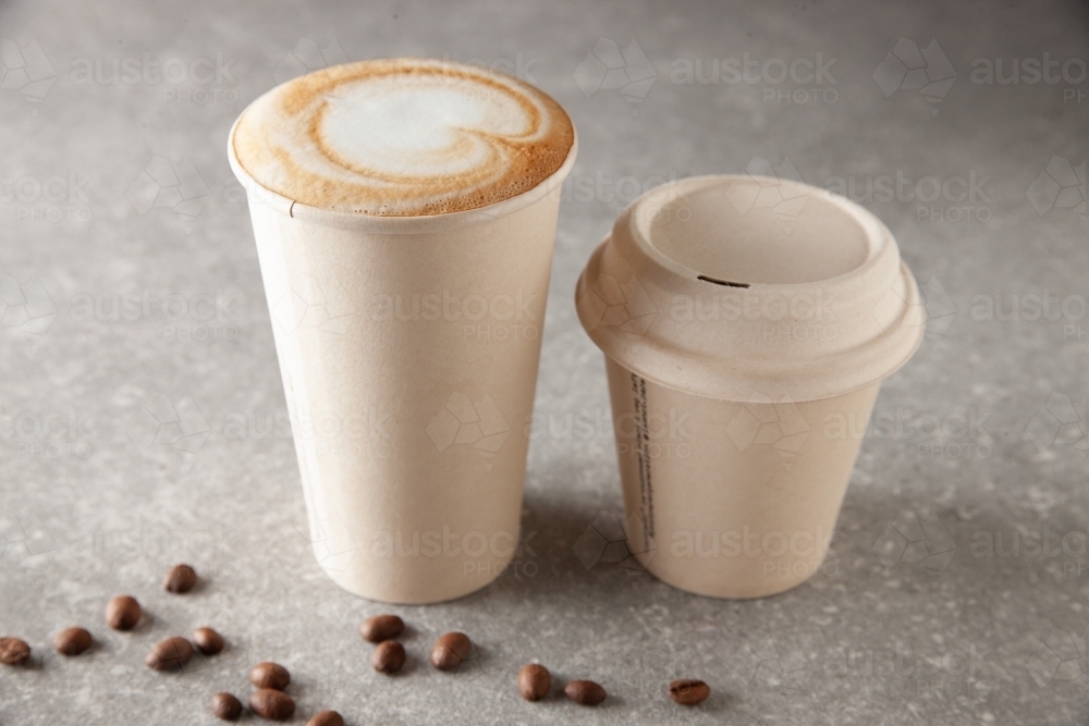 Two paper coffee cup sizes on table full of warm beverage - Australian Stock Image