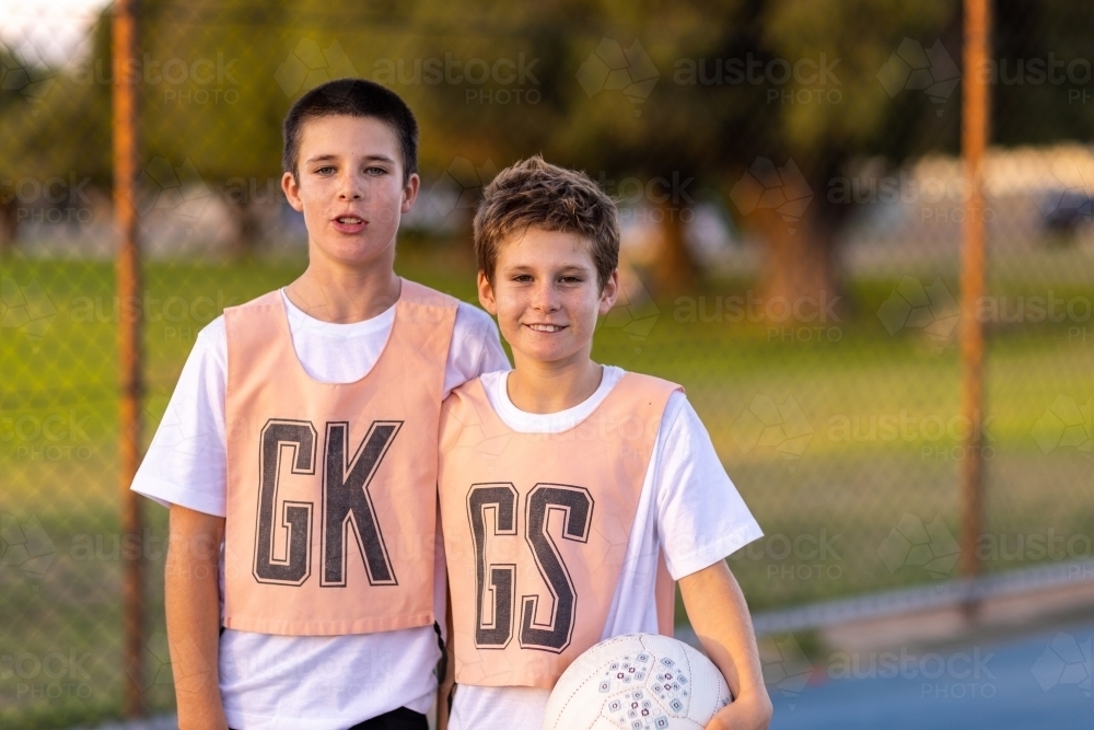 two school-aged boys wearing netball bibs and holding a netball - Australian Stock Image