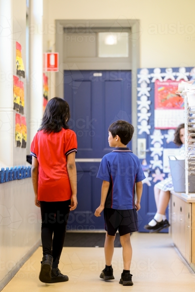 Two school students walking away in the corridor - Australian Stock Image