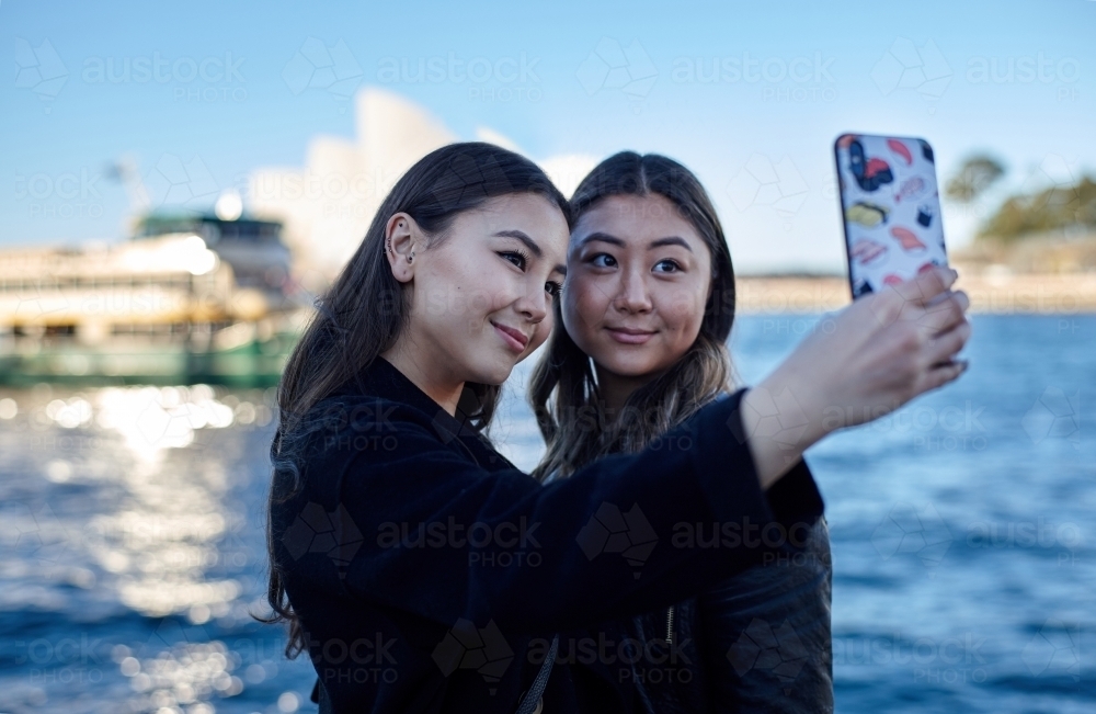 Two sisters spending time together harbourside taking selfie - Australian Stock Image