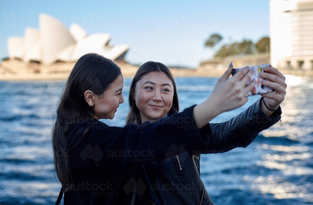 Two sisters spending time together harbourside taking selfie - Australian Stock Image