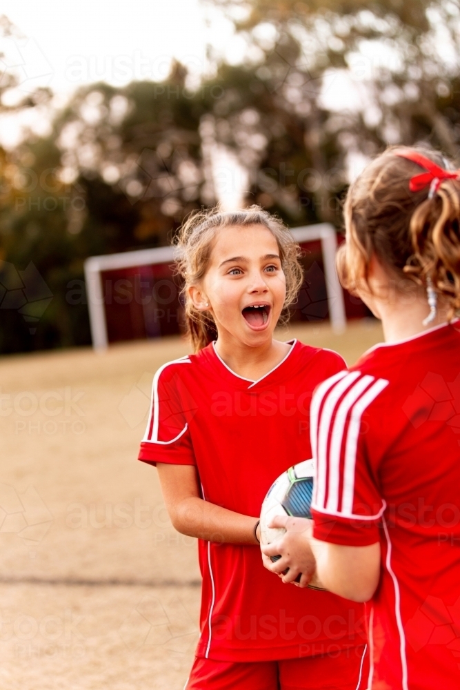 Two tween football players standing together at a sports oval - Australian Stock Image