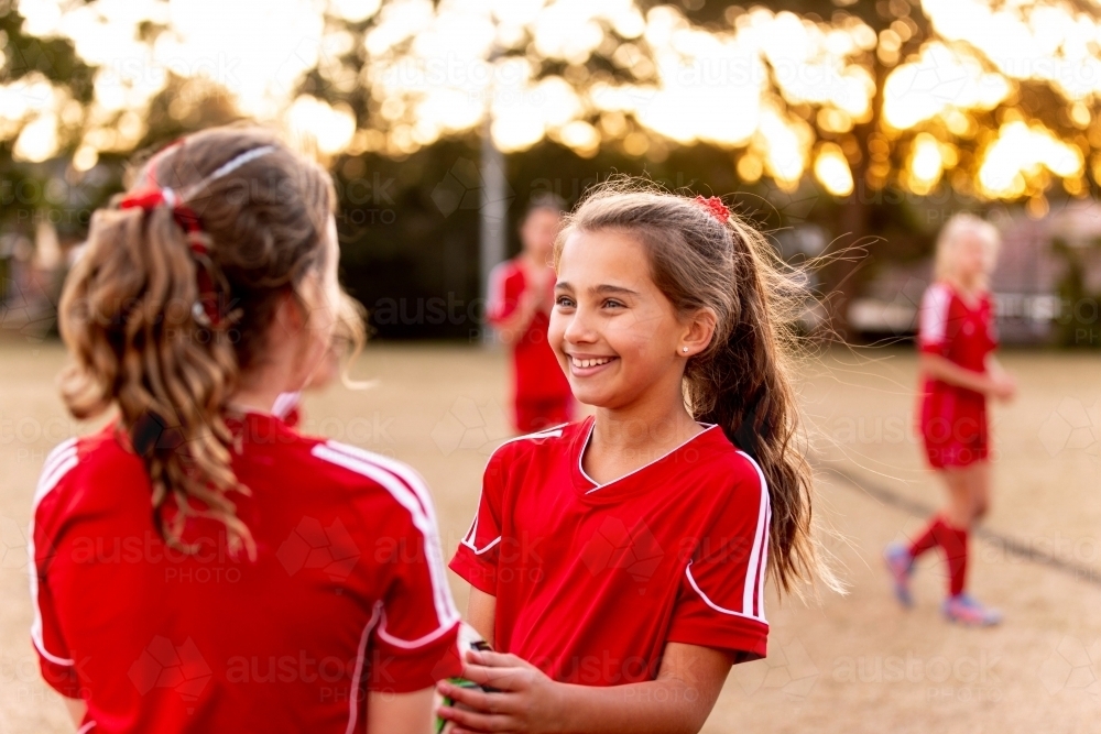 Two tween football players standing together at a sports oval - Australian Stock Image