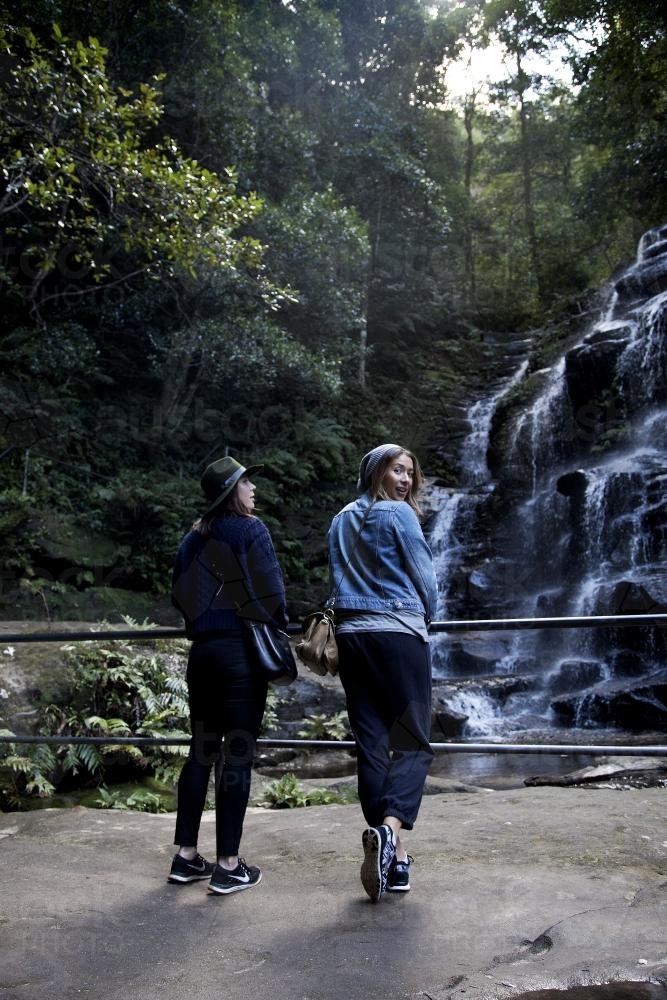 Two women on bush walk looking at waterfall - Australian Stock Image