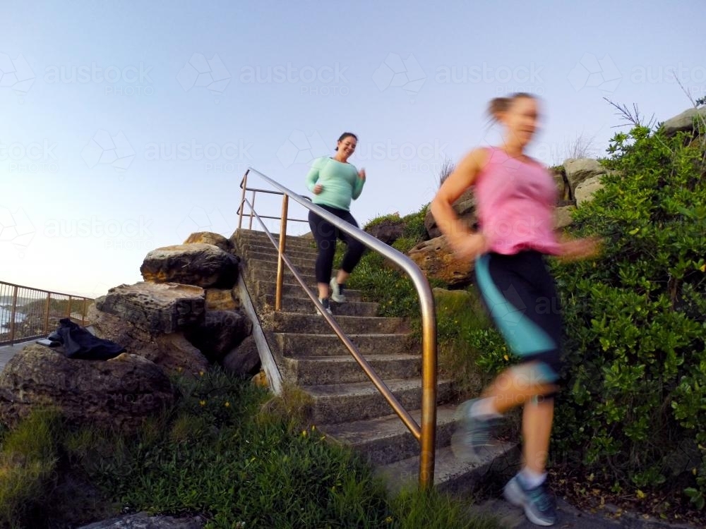 image-of-two-women-running-down-stairs-austockphoto