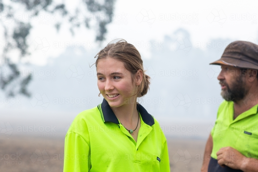 Two workers wearing hi-vis with smoky background - Australian Stock Image