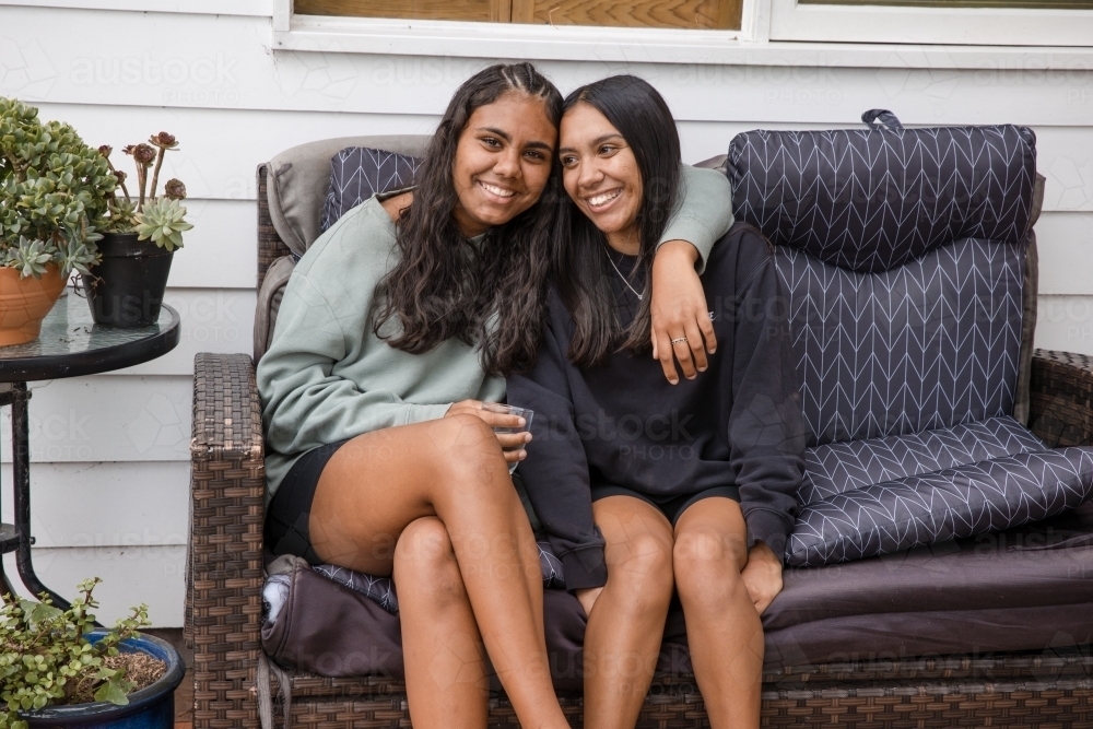 Two young Aboriginal women sitting together at home - Australian Stock Image