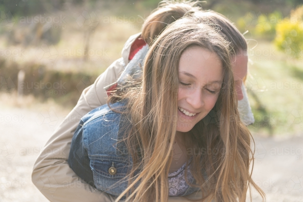 two young teenagers outside, hugging - Australian Stock Image