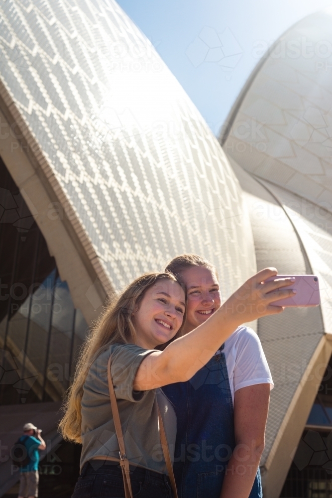 two young women posing in front of Sydney Opera House - Australian Stock Image