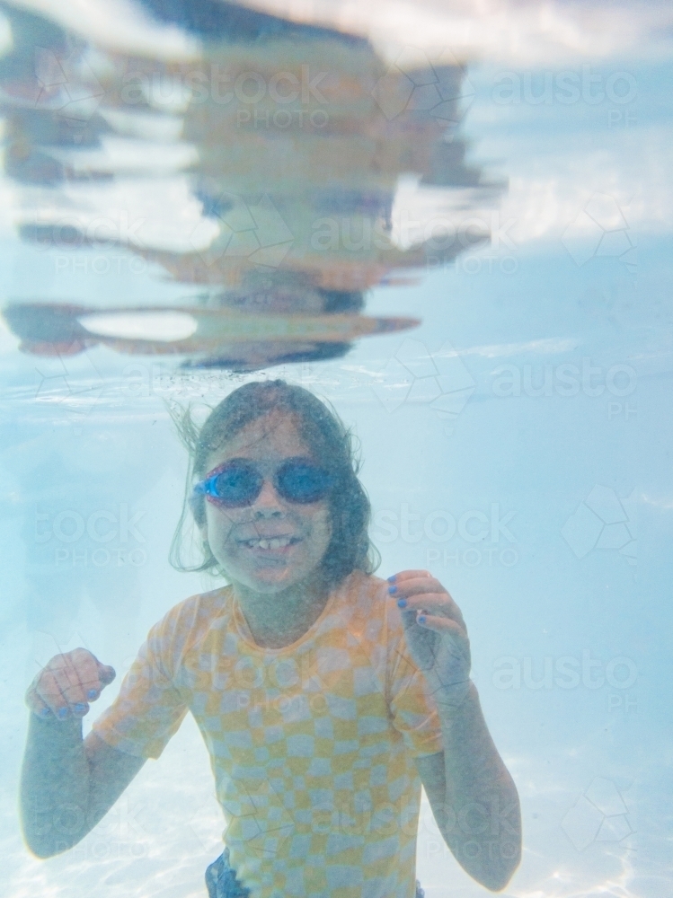 Underwater image of nine year old girl swimming in pool - Australian Stock Image