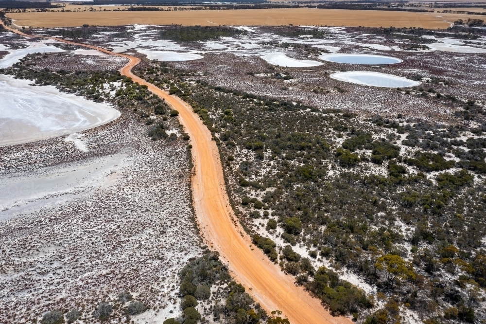 unsealed road meandering through area of salt lakes seen from above - Australian Stock Image