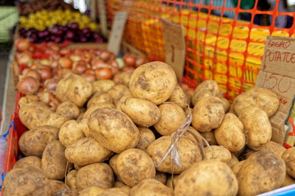 Unwashed potatoes for sale at a Sunday market - Australian Stock Image