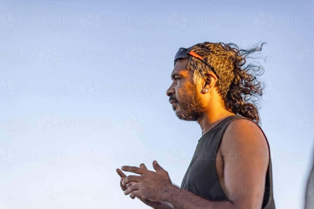 upper body of proud aboriginal man in profile against a clear blue sky - Australian Stock Image