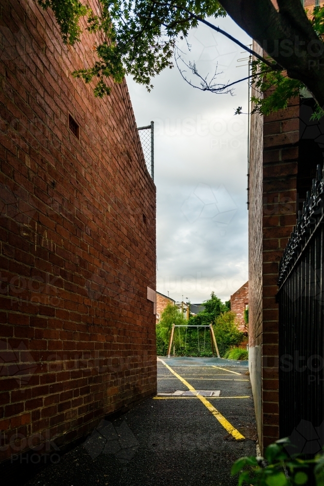 urban street scene, a playground down an alleyway between buildings - Australian Stock Image