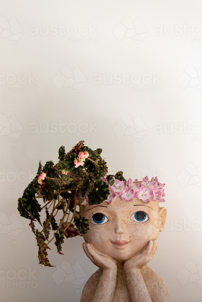 Vase shaped like a young girl with flowers in her hair - Australian Stock Image