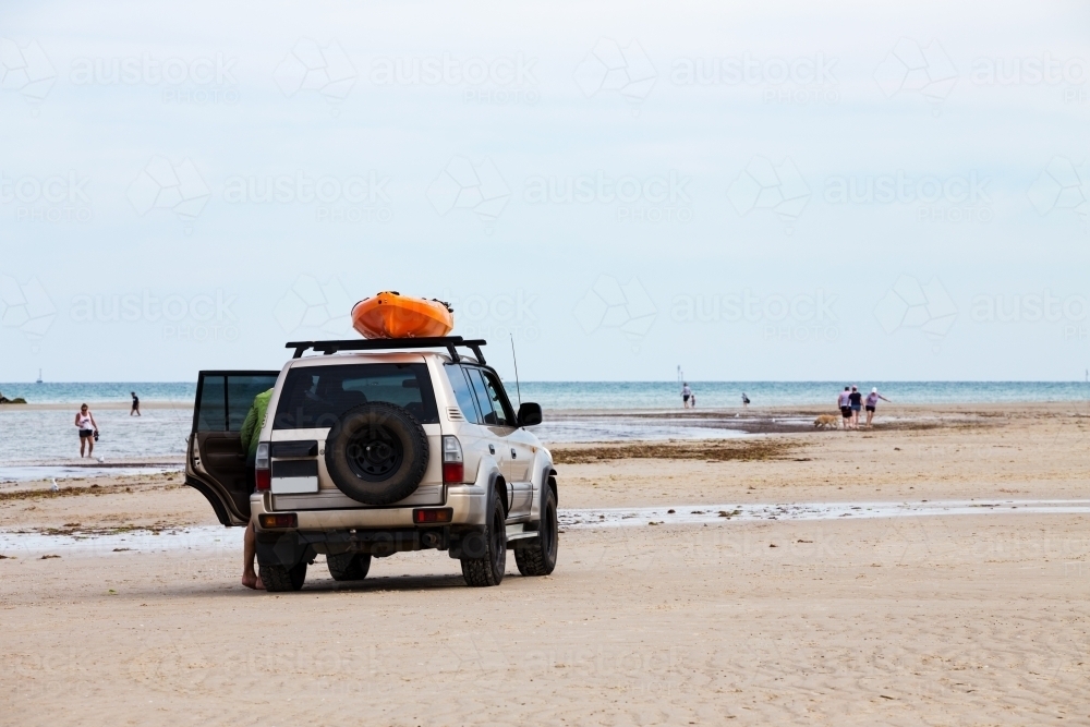 Vehicle on beach with kayak on roof - Australian Stock Image