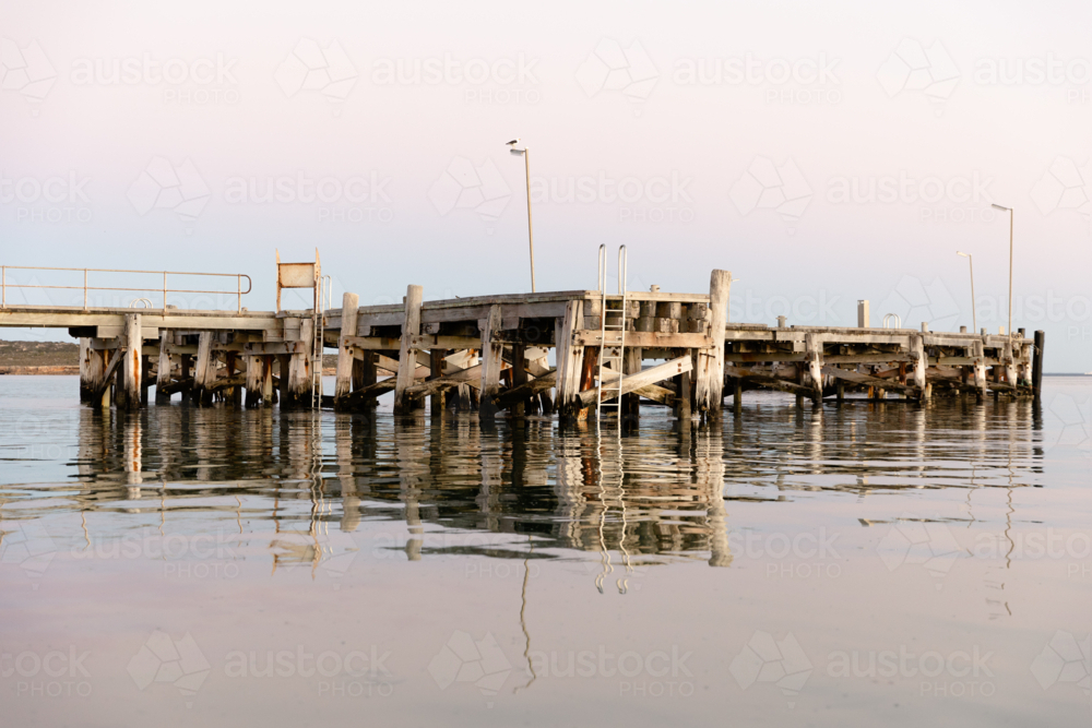 Venus Bay jetty reflecting on calm morning water - Australian Stock Image