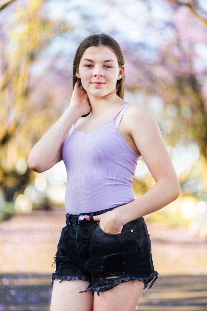 Young woman wearing shorts and tank top, smiling, oudoors - Stock