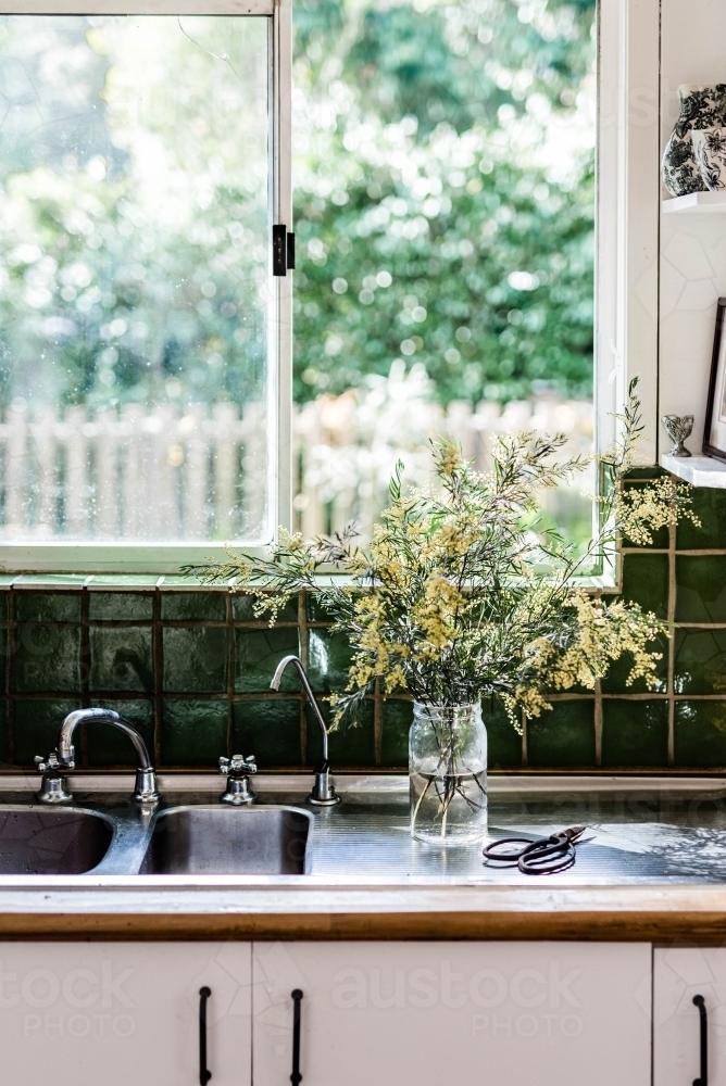 Vertical shot of a yellow plant prepared in the kitchen sink - Australian Stock Image