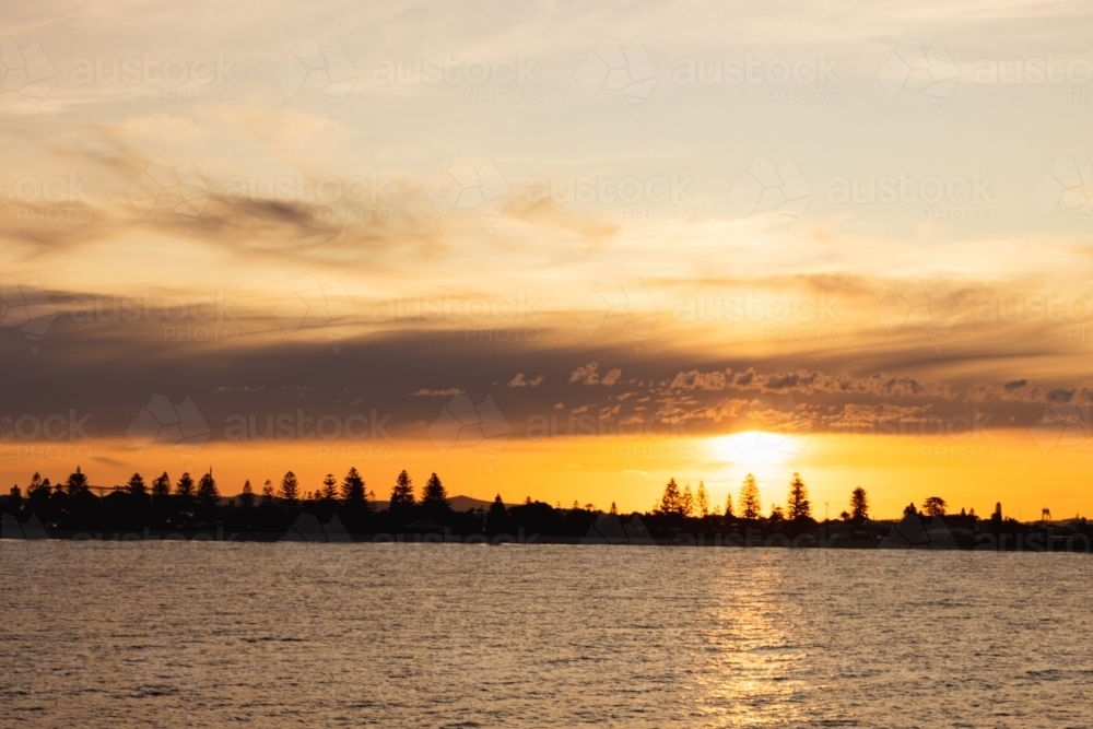 Vibrant orange sunset over Stockton NSW with view across the water - Australian Stock Image