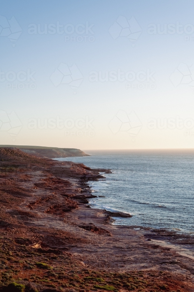 View along coastal rocky cliffs at sunset - Australian Stock Image