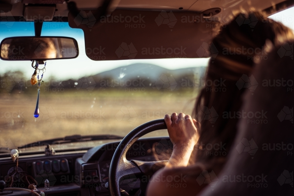 View from back of vehicle of woman driving van in regional area - Australian Stock Image