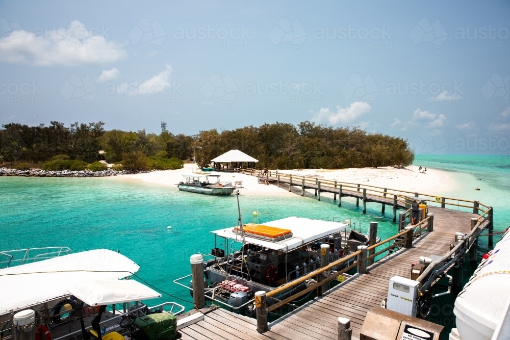 view of Heron Island jetty from the boat on sunlit day - Australian Stock Image