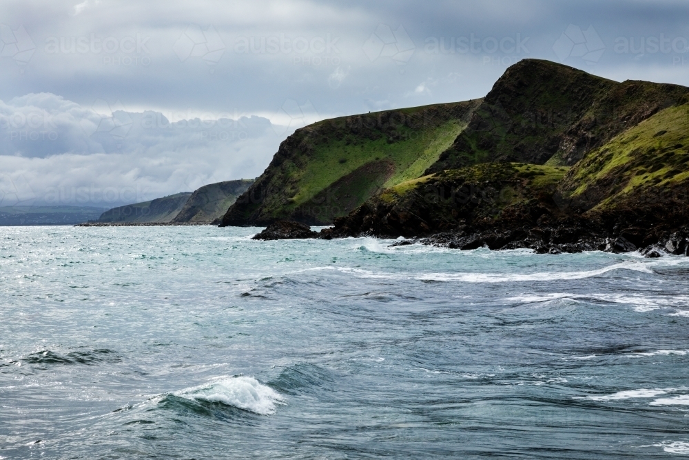 view of hilly coastline over water - Australian Stock Image