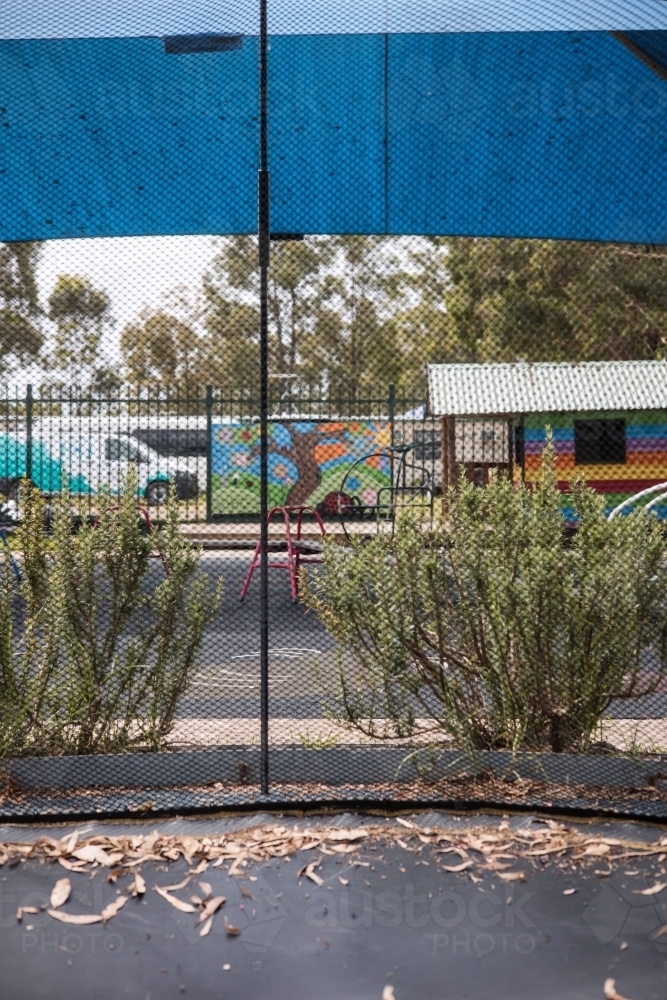 View of preschool yard from inside trampoline - Australian Stock Image