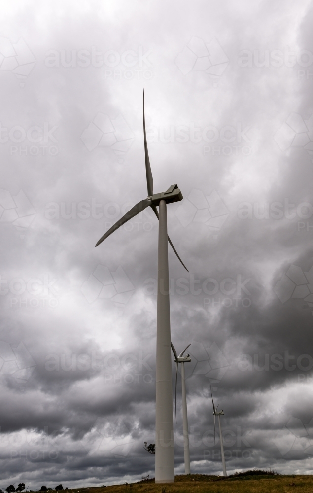 View of wind turbines with a dark and stormy sky - Australian Stock Image