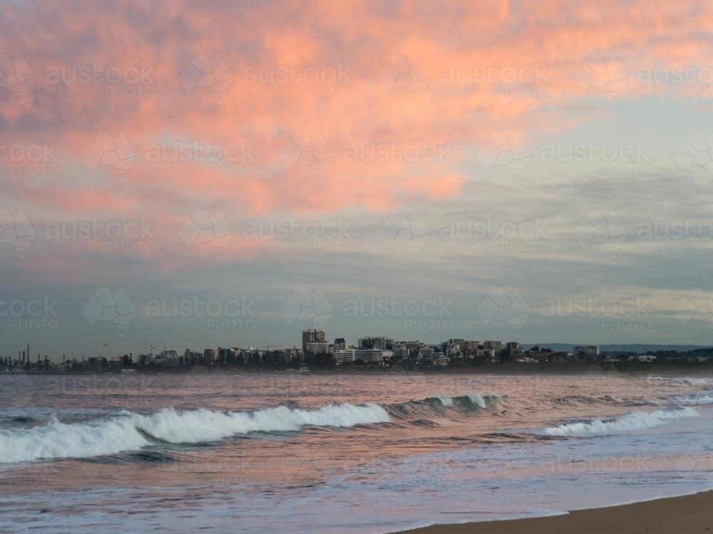 View of Wollongong across the sea at sunset - Australian Stock Image