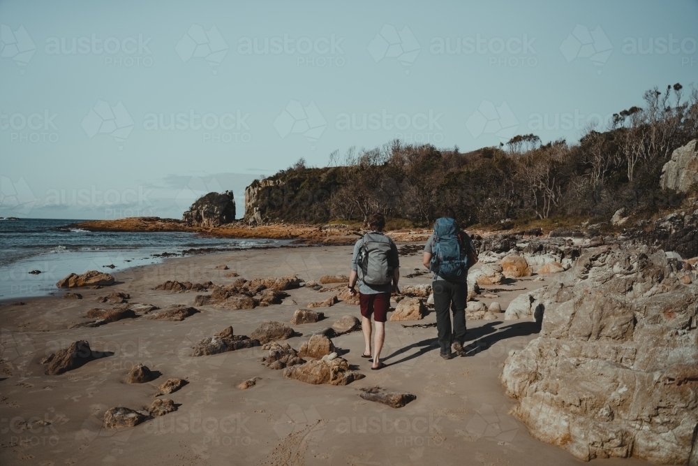 Walking along the beach to a rock climbing spot at Diamond Head Beach, NSW. - Australian Stock Image